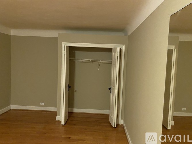 A room with a white door and a wooden floor.