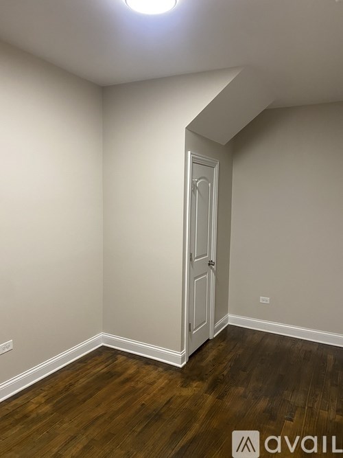 A room with a wooden floor and a white door.