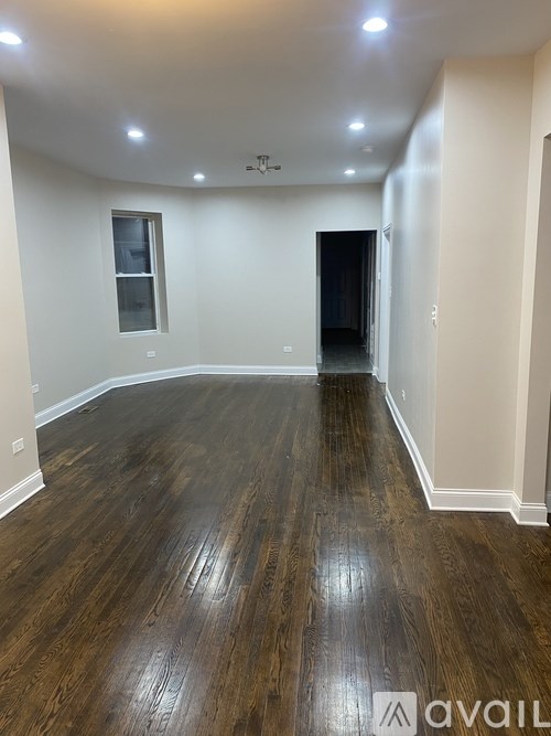 A room with wooden flooring and a window.