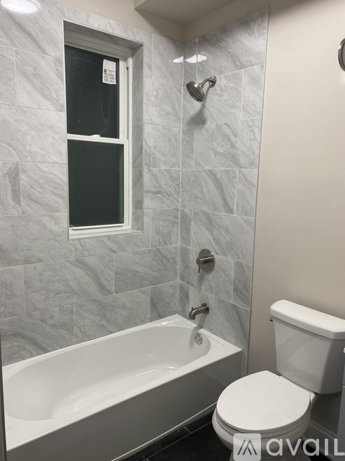 A bathroom with a toilet, tub, and shower.