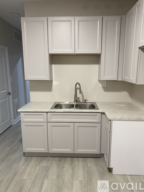 A kitchen with white cabinets and a sink.