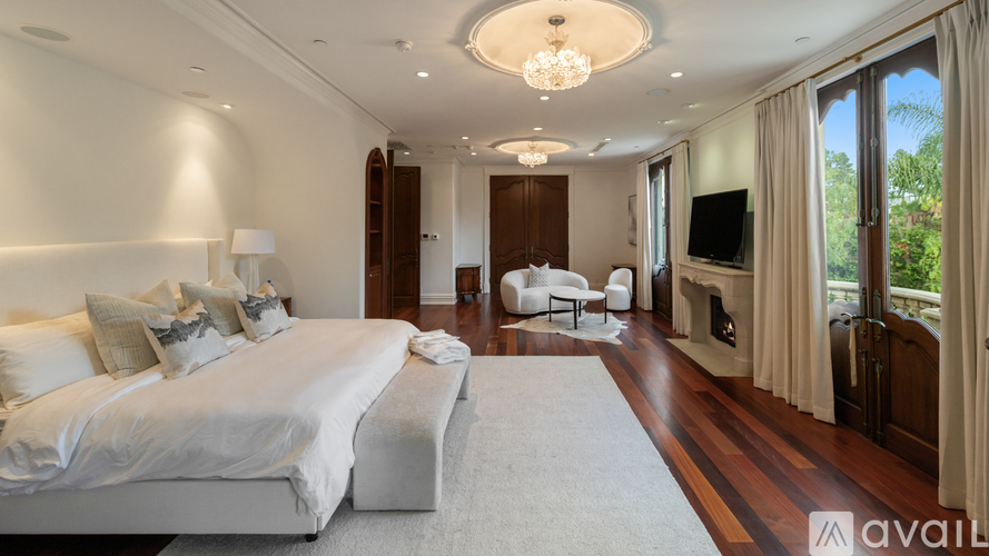 A bedroom with a large bed and a chandelier.