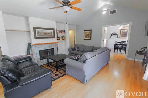 A living room with a black leather chair and a grey couch.