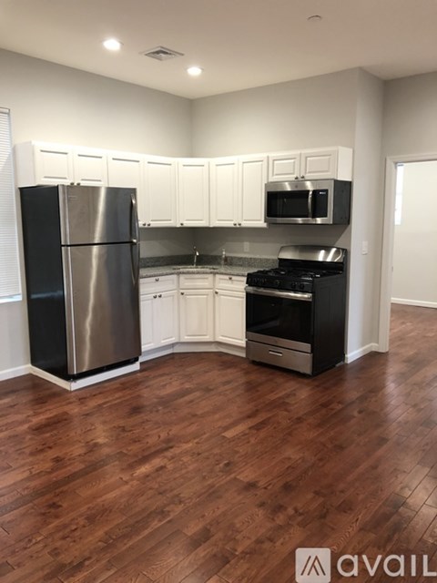 A kitchen with a refrigerator, stove, and microwave.