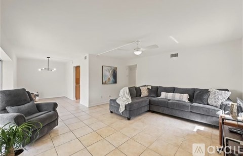 A living room with a grey couch and a grey armchair.