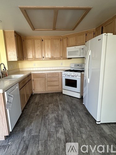 A kitchen with wooden cabinets and a white refrigerator.