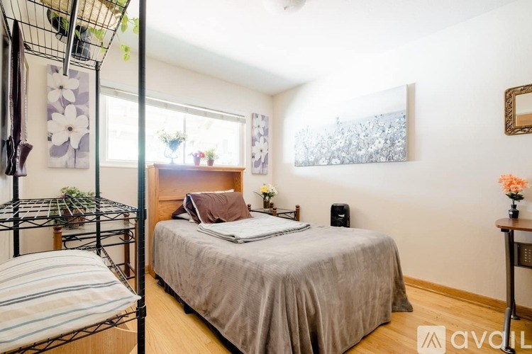 A bedroom with a bed, a nightstand, and a window.