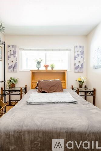 A bedroom with a bed, nightstands, and a window.