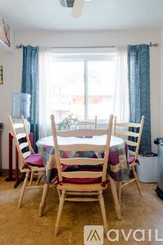 A dining room with a table and chairs.