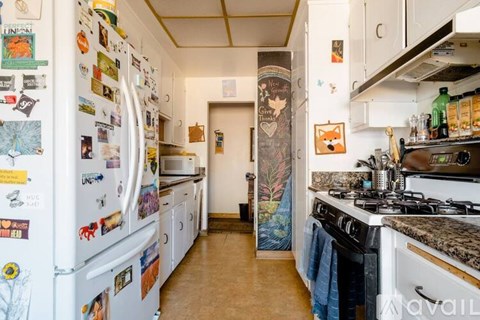 A kitchen with a white fridge covered in magnets and a stove top oven.