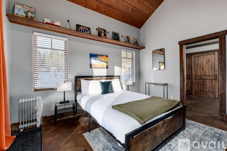 A bedroom with a large bed and a wooden headboard.