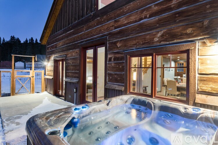 A wooden cabin with a hot tub outside.