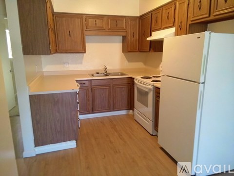 A kitchen with wooden cabinets and a white refrigerator.