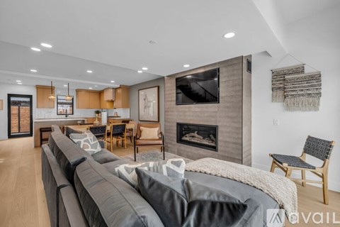 A modern living room with a grey sofa and a fireplace.