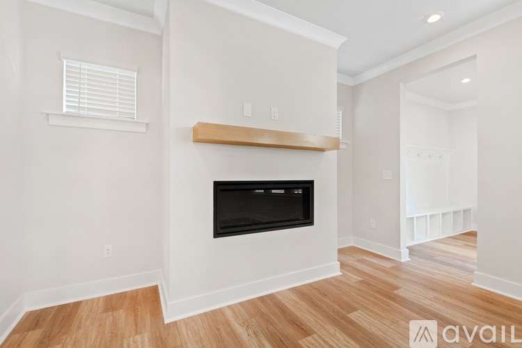 A living room with a fireplace and wooden floors.