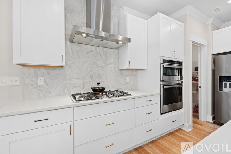 A modern kitchen with white cabinets and stainless steel appliances.