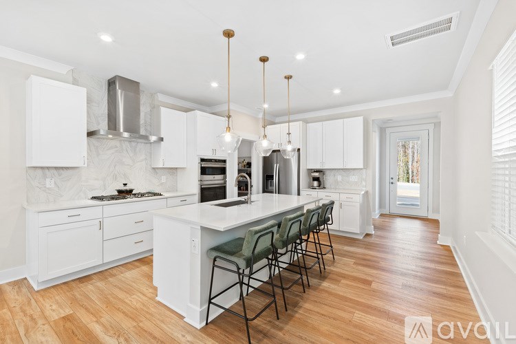 A kitchen with white cabinets and a wooden floor.