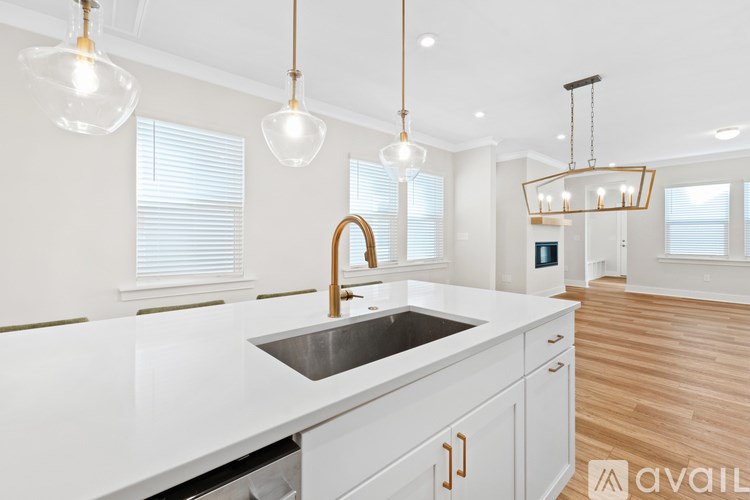 A modern kitchen with a white countertop and a stainless steel sink.