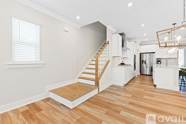 A spacious open plan living and kitchen area with wooden flooring.