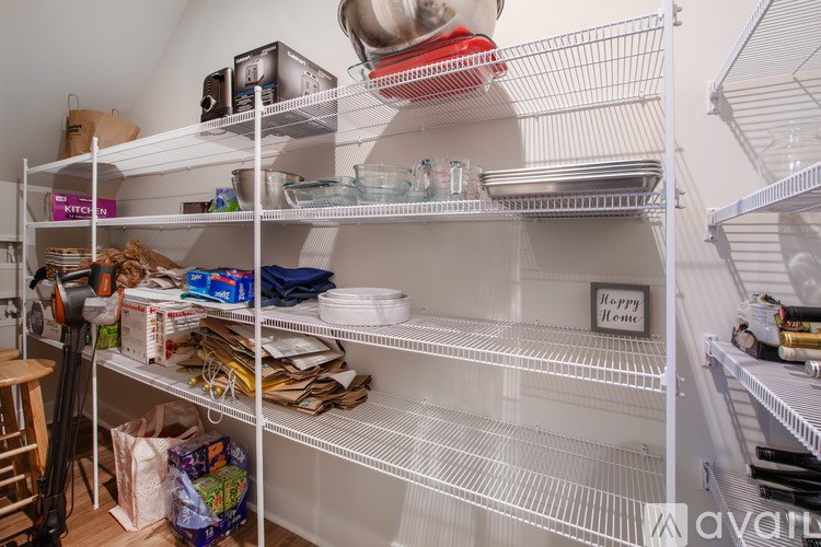 A white empty fridge with a sign that says "Happy Hour" on the bottom shelf.