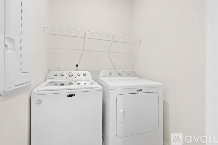 Two white front loading washing machines in a laundry room.