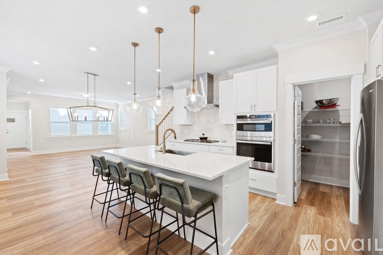 A modern kitchen with a center island and pendant lights.