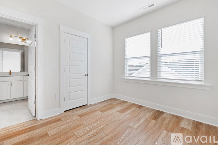 A room with a white door and a window with blinds.