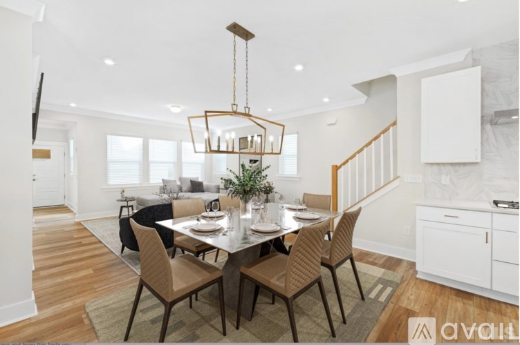 A dining room with a table set for six and a chandelier hanging from the ceiling.