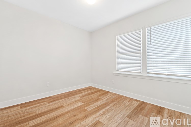 A room with wooden flooring and white walls.