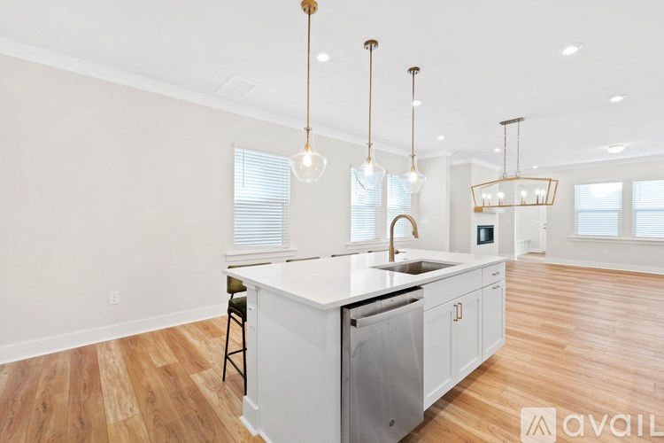A kitchen with a white countertop and wooden flooring.