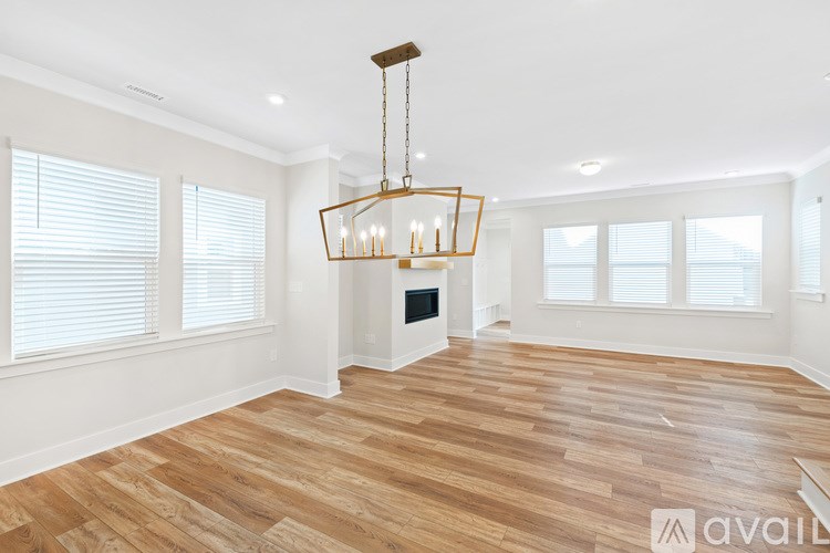 A large, empty room with wooden floors and a chandelier.