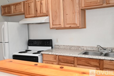 A kitchen with wooden cabinets and a white refrigerator.