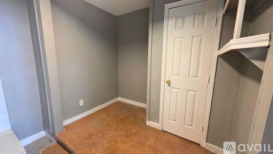 A room with a white door and a wooden floor.