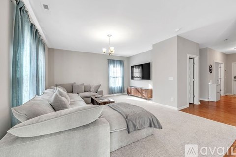 A spacious bedroom with a large bed and a television in the corner.