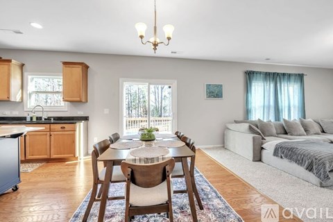 A well-lit, spacious living room with a dining table set in the center.