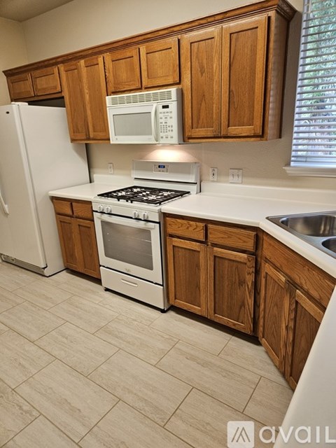 A kitchen with wooden cabinets and a white fridge.