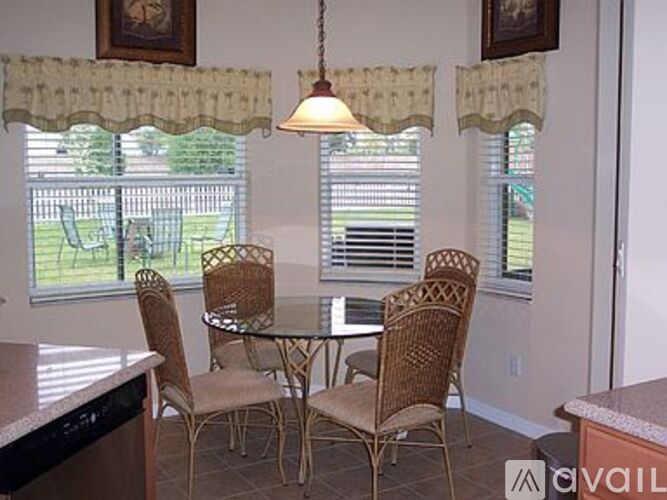 A kitchen with a table and chairs.