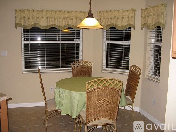 A dining room with a table and chairs.