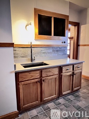 A kitchen with wooden cabinets and a stone backsplash.