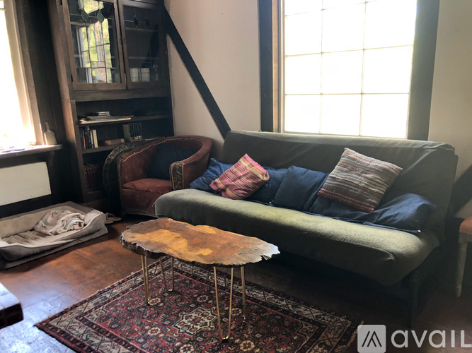 A living room with a green couch and a wooden floor.