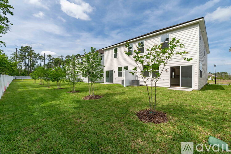 A house with a white exterior and a green lawn in front.