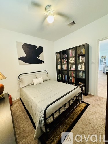 A bedroom with a large bed and a bookshelf.