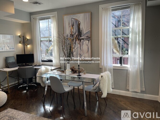 A modern dining room with a glass table and chairs.