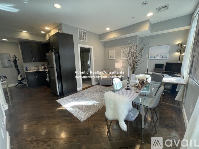 A kitchen with black cabinets and a white microwave.