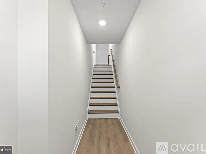 A staircase with wooden steps and a white wall on the side.