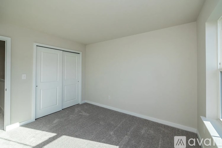 A room with a carpeted floor and a white door.