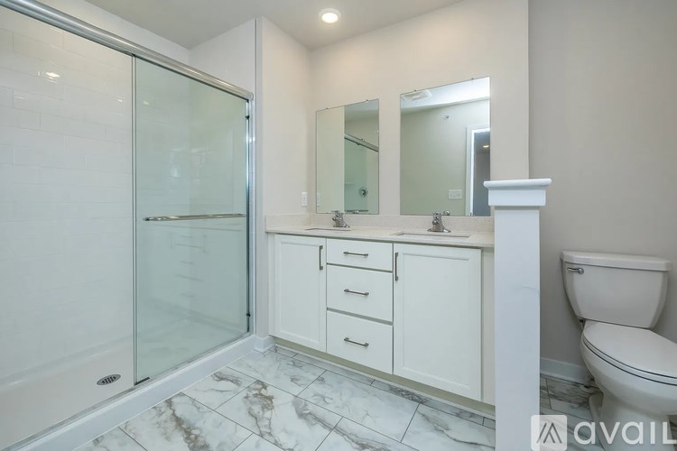A bathroom with a toilet, sink, and a walk-in shower.