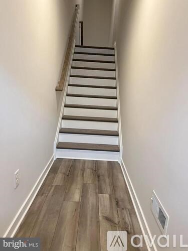 A staircase with wooden steps and a white railing.