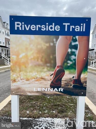A sign for the Riverside Trail is displayed on a grassy area.