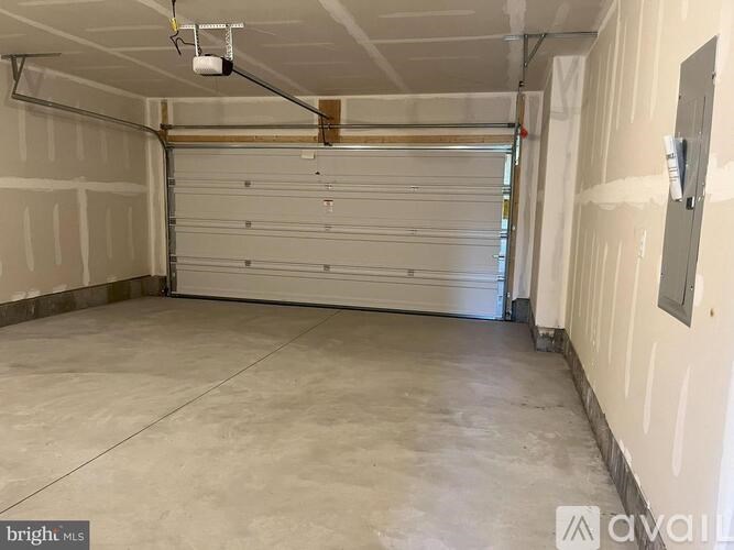 A spacious garage with a white door and a light hanging from the ceiling.